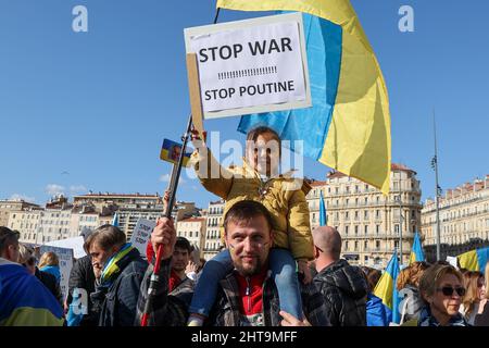 Marsiglia, Francia. 26th Feb 2022. Un bambino tiene un cartello mentre viene portato sulla spalla del padre durante la dimostrazione a sostegno del popolo ucraino e contro l'invasione militare russa. Credit: SOPA Images Limited/Alamy Live News Foto Stock