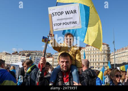 Marsiglia, Francia. 26th Feb 2022. Un bambino tiene un cartello mentre viene portato sulla spalla del padre durante la dimostrazione a sostegno del popolo ucraino e contro l'invasione militare russa. (Foto di Denis Thaust/SOPA Images/Sipa USA) Credit: Sipa USA/Alamy Live News Foto Stock