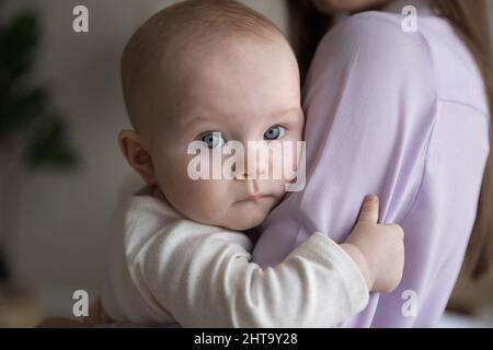 Ritratto di dolce bambino che riposa in braccia mamme Foto Stock