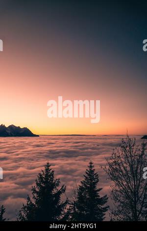 Scatto verticale del tramonto da sopra le nuvole Foto Stock