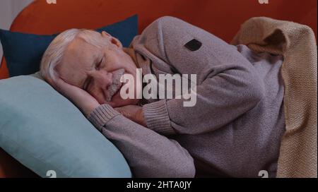 Anziano sorridente uomo nonno che dorme tranquillamente sdraiato a letto a casa, sano buon sonno tranquillo Foto Stock