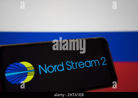 Grecia. 27th Feb 2022. In questa illustrazione della foto, il logo Nord Stream 2 viene visualizzato sullo schermo di uno smartphone e la bandiera della Russia viene visualizzata sullo sfondo.Nord Stream è un sistema di gasdotti che trasferisce gas naturale dalla Russia all'Europa. Credit: SOPA Images Limited/Alamy Live News Foto Stock