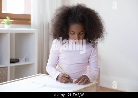 Concentrato African American teen girl disegno immagini in album. Foto Stock