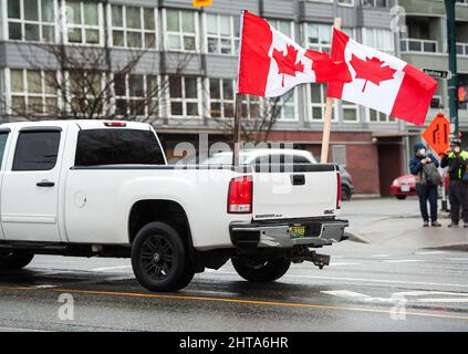 Un camion pick up batte bandiere canadesi a sostegno del convoglio canadese di libertà Trucker sostenitori scontrarsi con Vancouver locale contro i manifestanti in Oriente Foto Stock