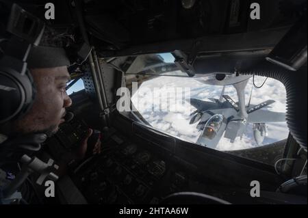 U.S. Air Force staff Sgt. Barnes Kadrick, 351st Air Refeling Squadron Boom Operator, fornisce combustibile a F15E Strike Eagle over Eastern Europe, 26 febbraio 2022. La missione ARS 351 è quella di migliorare l'interoperabilità con le nazioni alleate e partner in Europa e nel mondo. (STATI UNITI Air Force Airman 1st classe Edgar Grimaldo) Foto Stock