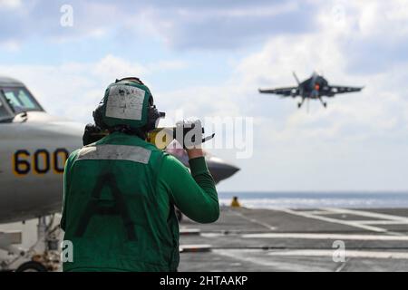 MAR DELLE FILIPPINE (Feb 26, 2022) Aviation Boatswain’s Mate (Equipment) Airman Riley Odum, di Litchfield, N.H., osserva le operazioni di volo sul ponte di volo della portaerei di classe Nimitz USS Abraham Lincoln (CVN 72). Abraham Lincoln Strike Group è in fase di implementazione pianificata nell'area delle operazioni della flotta USA 7th per migliorare l'interoperabilità attraverso alleanze e partnership, fungendo da forza di risposta pronta a supportare una regione indopacifica libera e aperta. (STATI UNITI Foto Navy di Mass Communication Specialist 3rd Classe Javier Reyes) Foto Stock