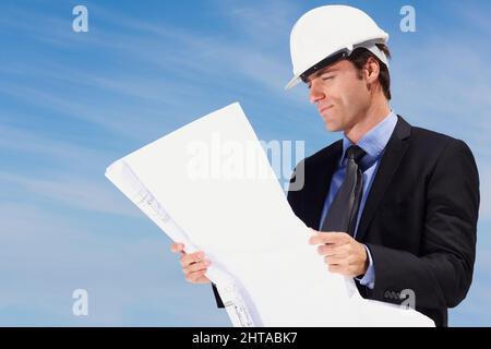 Architetto intelligente che guarda a un nuovo piano di costruzione. Ritratto di un architetto intelligente che guarda un piano di costruzione. Foto Stock