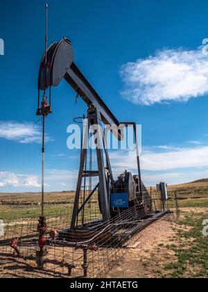 Petrolio Pumpjack o pozzo di petrolio trovato nella contea di Weston, Wyoming sulla prateria aperta ancora in funzione Foto Stock