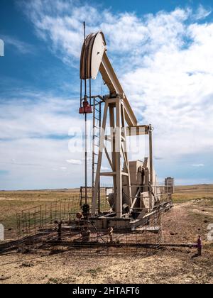 Petrolio Pumpjack o pozzo di petrolio trovato nella contea di Weston, Wyoming sulla prateria aperta ancora in funzione Foto Stock