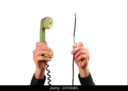 un ricevitore telefonico in mano e cavi rotti. isolato su sfondo bianco Foto Stock