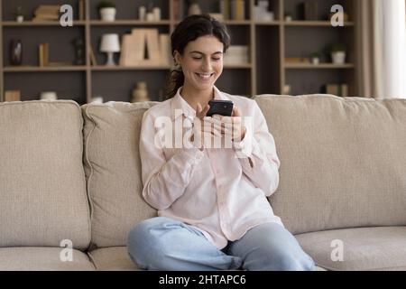 Sorridendo bella giovane ispanica con smartphone. Foto Stock