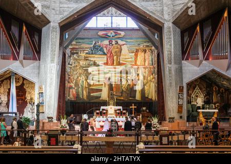 Una cerimonia di nozze cristiana è condotta sotto un grande mosaico nella Chiesa superiore della Basilica dell'Annunciazione a Nazareth, Israele. Foto Stock