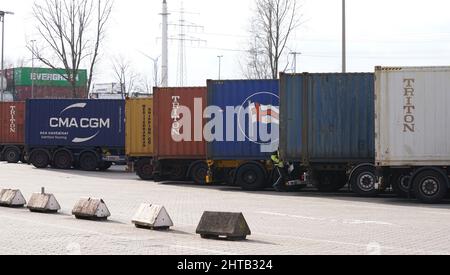 Amburgo, Germania. 24th Feb 2022. I camion con container marini si trovano in un parcheggio nel porto di Amburgo. Il Porto di Amburgo Marketing informa il 28.02.2022 sulla movimentazione dei carichi marittimi 2021. Credit: Marcus Brandt/dpa/Alamy Live News Foto Stock