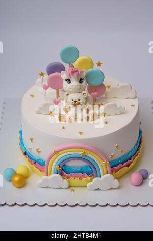 Foto di un disegno di torta unicorno con arcobaleno su sfondo bianco Foto Stock