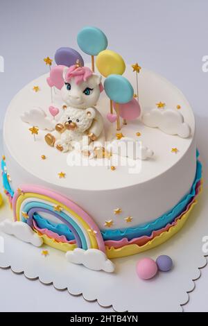 Foto di un disegno di torta unicorno con arcobaleno su sfondo bianco Foto Stock