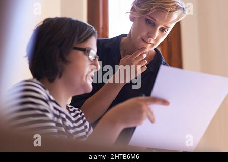 Mettendo le loro teste insieme. Un taglio corto di due donne che lavorano insieme in un ufficio domestico. Foto Stock