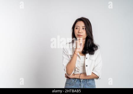 donna asiatica che pensa qualcosa e guarda in su Foto Stock