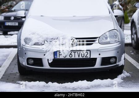Vista frontale di un'auto da golf Volkswagen grigia parcheggiata coperta di neve in inverno Foto Stock