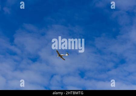 Piccolo aereo ultraleggero vola contro il cielo blu con le nuvole. Sport estremi, sfondo di viaggio con spazio per la copia Foto Stock