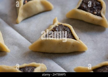 Le "tasche di Haman" precotte, note anche come Hamantashen, un Ashkenazi Jewish triangolare riempito-tasca biscotti, di solito associati con la festa ebraica Foto Stock