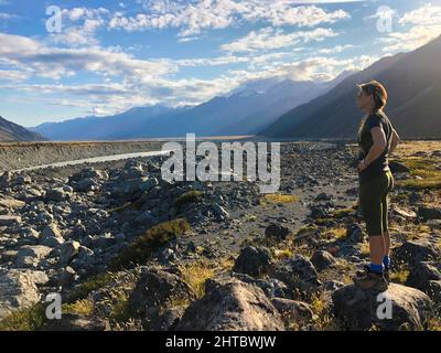 Donna caucasica che guarda alla distanza nella valle di Hooker che conduce a Monte Cook Aoraki in Nuova Zelanda Foto Stock