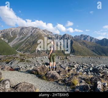 Donna caucasica che guarda alla distanza nella valle di Hooker che conduce a Monte Cook Aoraki in Nuova Zelanda Foto Stock