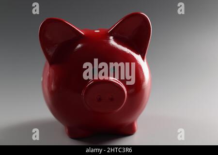 Contenitore rosso piggybank sulla superficie grigia, cosa per risparmiare denaro, animale in ceramica Foto Stock