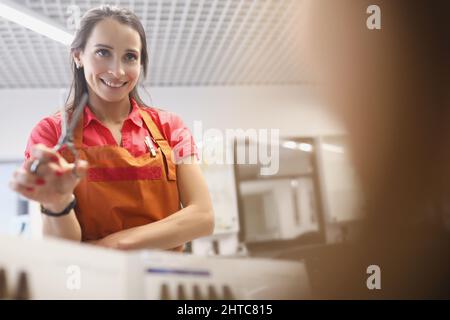 Sorridente padrone tenere forbici, prepararsi a tagliare i capelli, cliente in sedia attendere il servizio Foto Stock