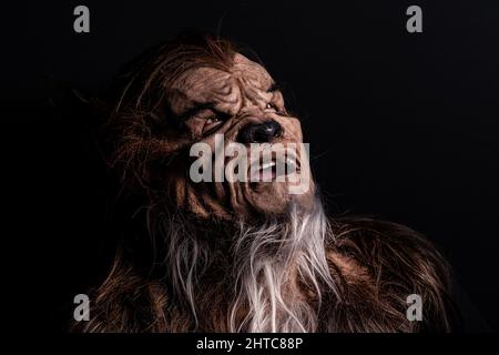 Persona che indossa una maschera di un lupo mannaro su sfondo scuro Foto Stock