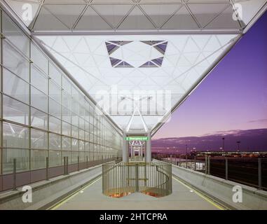 Aeroporto di Stansted, Stansted, Stansted Mountfitchet, Uttlesford, Essex, 21/01/1991. La piattaforma tra le rotaie della navetta per il trasporto passeggeri nel nuovo edificio del terminal dell'aeroporto di Stansted illuminata di notte. Laing Management Contracting è stato nominato ‘consulente appaltatore’ per lo sviluppo di Stansted nell'ottobre 1985. Lo sviluppo includeva un nuovo accesso stradale dal M11, un nuovo collegamento ferroviario con Londra e il nord, un parcheggio a breve e lungo termine, nuovi taxi e grembiuli, e un nuovo edificio terminal con un sistema automatizzato di transito passeggeri. I lavori sul sito sono iniziati in AP Foto Stock