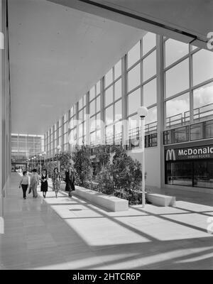 The Shopping Centre, Silbury Boulevard, Milton Keynes, Buckinghamshire, 01/07/1979. Gli amanti dello shopping passeggiando accanto alle piantagioni tropicali in una delle arcate soleggiate del centro commerciale Milton Keynes. Foto Stock