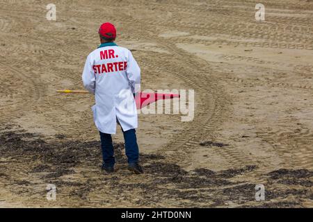 MR Starter - vista posteriore dell'uomo che indossa MR Starter cappotto per iniziare le gare all'evento di corse di motocross sulla spiaggia di Weymouth, Weymouth, Dorset UK nel mese di ottobre Foto Stock