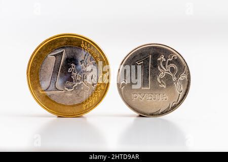 Monete da 1 euro e 1 rubli su sfondo bianco. Concetti di tassi di cambio, transazioni finanziarie e scambi commerciali tra l'UE e la Russia Foto Stock