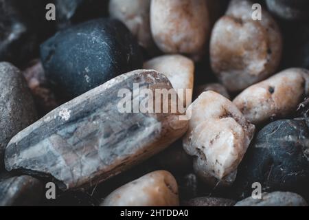Primo piano di grande grunge pietra su un piccolo ciottoli pietre Foto Stock