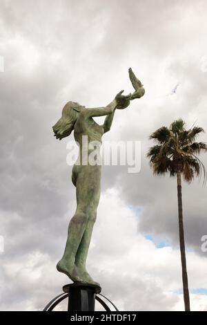 Statua di una donna che rilascia una colomba lungo il lungomare di Fuengirola Foto Stock