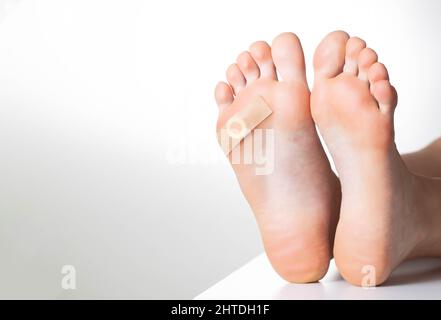 Piede donna con cerotto medico incollato per verruca plantare. Trattamento di calli e verruche sui piedi, dermatologico Foto Stock