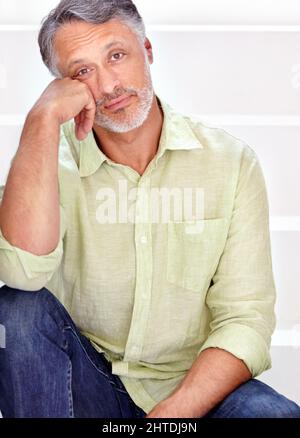 HES ha ottenuto grande fiducia sul posto di lavoro. Un bel uomo maturo seduto su una scala. Foto Stock