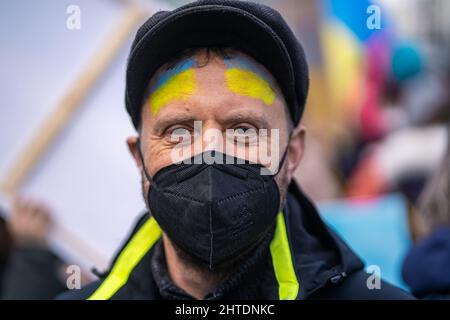 Ritratto di vecchio con bandiera Ucraina in faccia. Proteste contro la guerra dopo che la Russia invade l'Ucraina Foto Stock