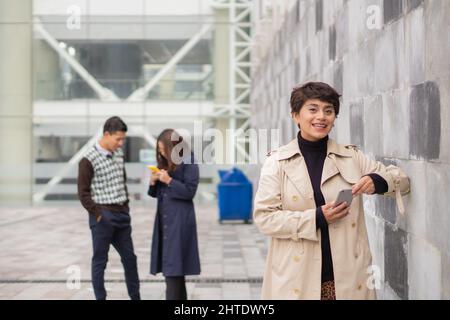 Donna con i suoi colleghi in primo piano. Analisi di tutti i dati del lavoro e della produttività. Foto Stock