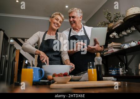 Caucasica coppia superiore cottura ridendo insieme nel kicthen Foto Stock