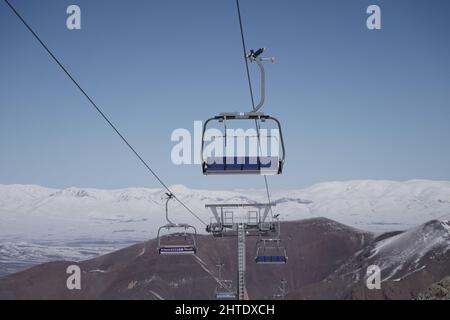 Seggiovie vuote nella stazione sciistica e Snowy Mountain in background Foto Stock