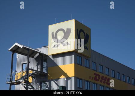 Saulheim, Germania, 27 febbraio 2022. DHL edificio per uffici con cielo blu presso il centro di distribuzione DHL Package Saulheim. Foto Stock