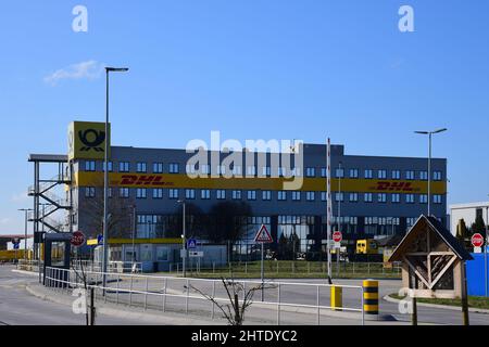 Saulheim, Germania, 27 febbraio 2022. DHL edificio per uffici con cielo blu presso il centro di distribuzione DHL Package Saulheim. Foto Stock