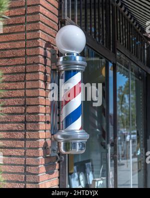 Los Angeles, CA, USA - 25 febbraio 2022: Primo piano di un tradizionale Barber’s Pole di fronte a un barbiere di Los Angeles, California. Foto Stock