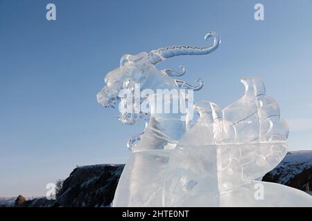 Grande testa di drago in ghiaccio trasparente contro il cielo blu. Baikal 20 febbraio 2022 Foto Stock