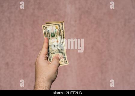 Primo piano di una mano maschile contenente banconote da 50 dollari. CopySpace Foto Stock