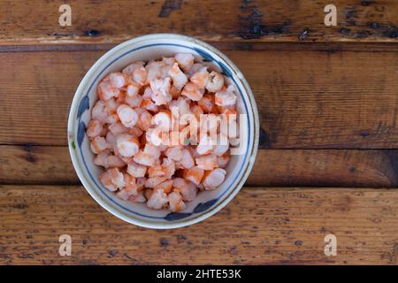 Ciotola di gamberi su un tavolo di legno Foto Stock