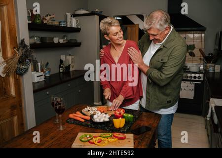 Affettuoso anziano coppia cucinare in cucina insieme Foto Stock