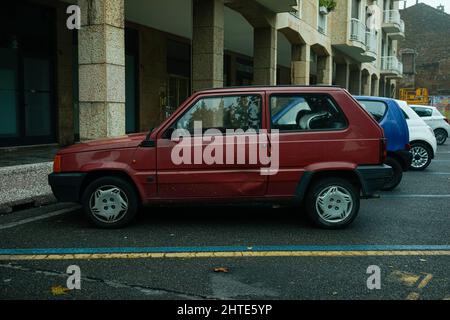 Vista laterale di un'auto italiana d'epoca Fiat Panda con una porta danneggiata parcheggiata di fronte a un edificio Foto Stock