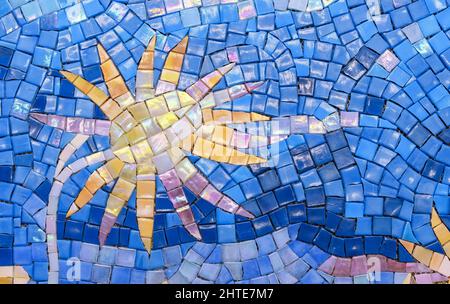 Fiore giallo fatto da piastrelle mosaico in ceramica su sfondo blu. Foto Stock
